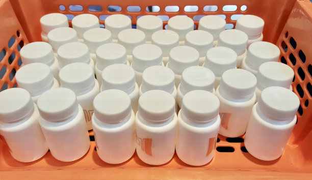 一张照片里的篮子里装满了药瓶，药瓶里有一篮子白色的瓶子放在桌子上。图片下载