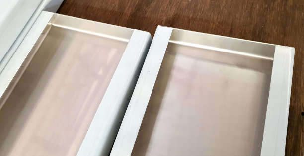 木地板上一对白色抽屉的照片，木地板上有两个开着门的药柜。图片下载