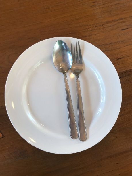 木桌上有勺子和叉子的空盘子，库存照片图片下载