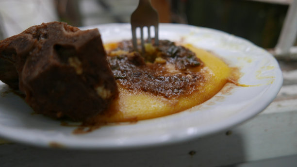 可以吃的食物。午休时间。午餐是玉米粥、猪肉和洋葱酱。自制玉米粥，特写，侧视图。玉米粥盘(煮熟的玉米粉)。排骨。煮熟的猪肉。意大利菜。煮玉米粥。煮玉米粥。午餐时间图片下载