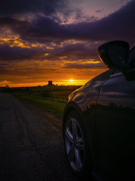 加拿大爱德华王子岛肯辛顿2号公路上的日出路边景观，地平线上戏剧性的云景，部分停放的汽车图片下载
