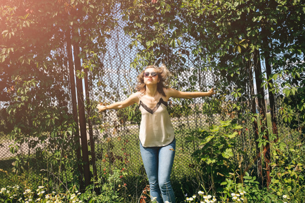 时髦的时髦女孩站在户外常春藤叶墙附近。为年轻女性拍摄时尚照片。金色短发，戴着酷酷的眼镜。图片下载