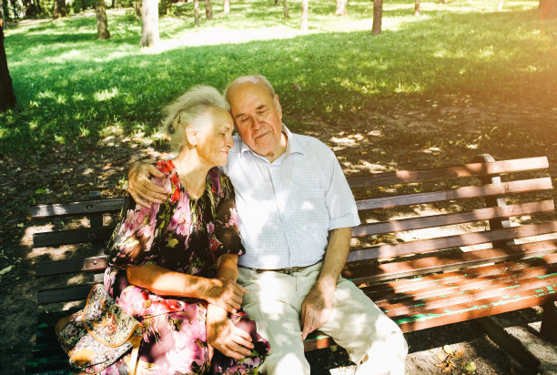 漂亮的老夫妇坐在公园的长椅上。奶奶和爷爷在户外拥抱。金婚纪念日快乐。奶奶和爷爷的浪漫照片。真正的爱。图片下载