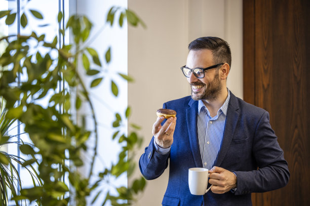 工作时吃甜甜圈喝咖啡的商人。图片下载