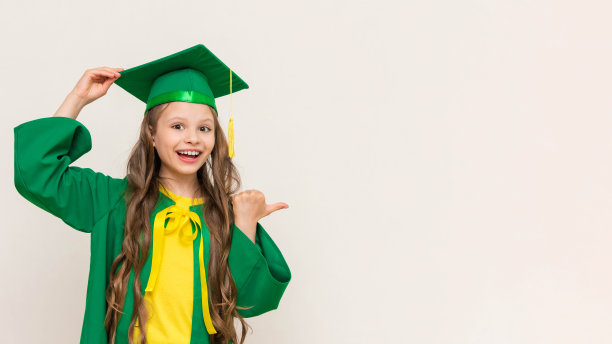 一个打扮成硕士学位的女学生指向你的广告。一个参加初中毕业典礼的孩子。儿童教育。白色孤立的背景。副本的空间。横幅。图片下载