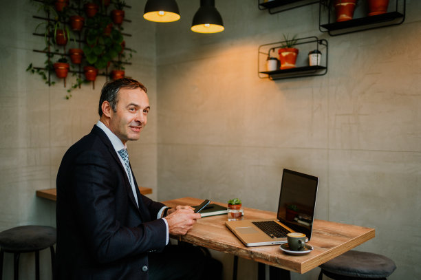 坐在酒吧里的商人带着温柔的微笑望向远方图片下载