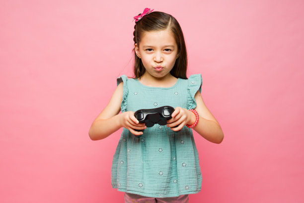 漂亮的小学生在玩电子游戏图片下载