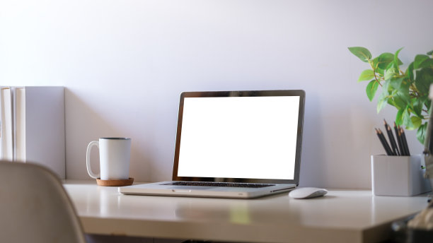 舒适的家庭办公室。白色桌子上的笔记本电脑、文具和盆栽。图片下载