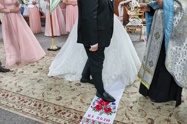 在婚礼上，新娘和新郎站在一个刺绣的牛头牌上。图片下载