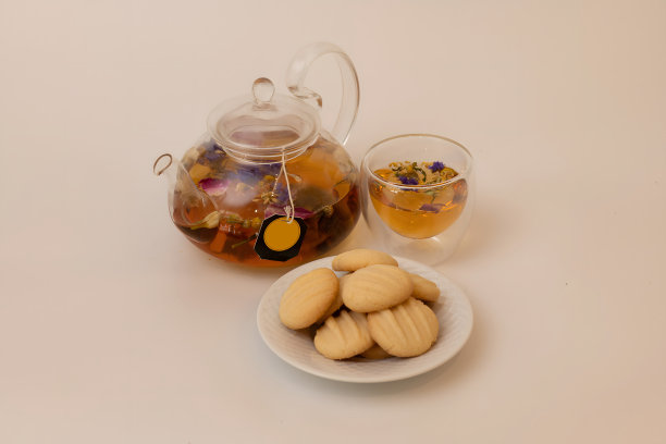 花茶派对套装。茶壶里放着一杯茶和黄油饼干，孤立的背景图片下载