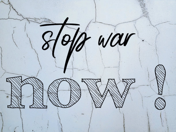 照片上是一堵被严重破坏的裂缝墙，上面写着“停止战争”图片下载