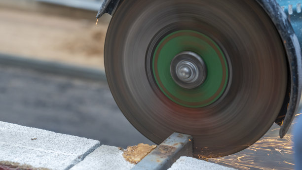 近景的工人与角磨床工作。钢结构电动砂轮磨削。火花。图片下载