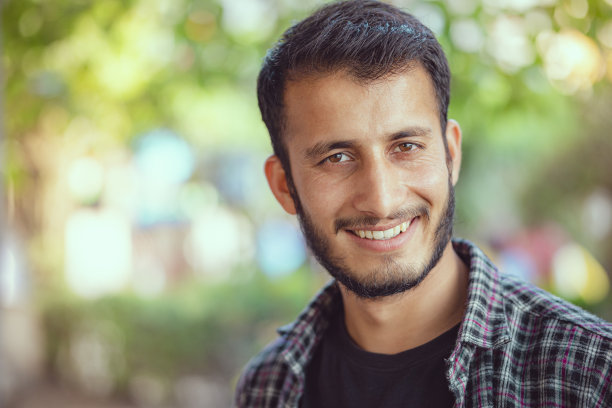 户外的一天肖像一个快乐的年轻人看着相机。图片下载