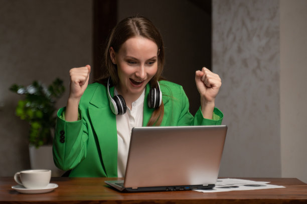 戴着耳机的女人在笔记本电脑上竞争图片下载