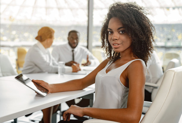 非洲女商人坐在办公室使用平板电脑图片下载