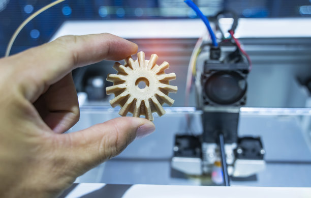 手与物体的齿轮打印在3d打印机上的特写图片下载