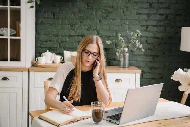 家庭作业。女人打电话，工作，学习，使用笔记本电脑在家庭办公室。自由职业者。在笔记本上写字，打字。沟通，技术理念。文书工作。营销，学习，设计图片下载