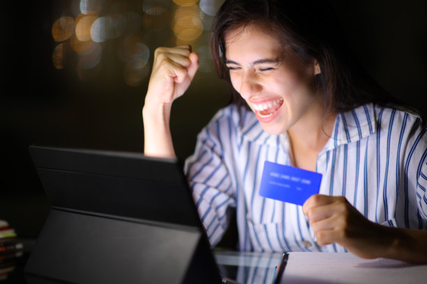 兴奋的女人在夜里用平板电脑网购图片下载