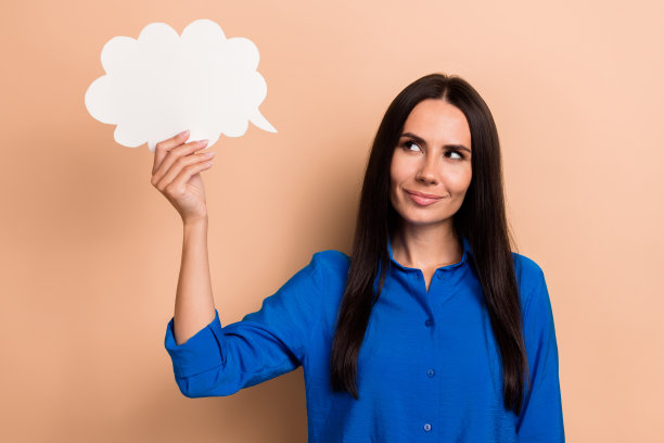 照片的头脑漂亮的女士穿着蓝色时尚的衣服，手握纸卡空的空间信息新闻孤立在米色背景图片下载