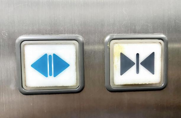 金属表面上两个按钮的照片，上面有一个蓝色的箭头和一个蓝色的箭头。图片下载