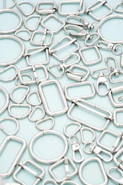 包、背包用镀铬金属配件及用品。淡蓝色的背景上放着一堆做包和背包的金属配件。手袋制作、缝纫配件图片下载