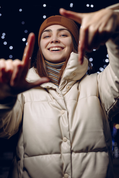 在冬天的城市里，一个快乐的女人摆姿势拍照图片下载