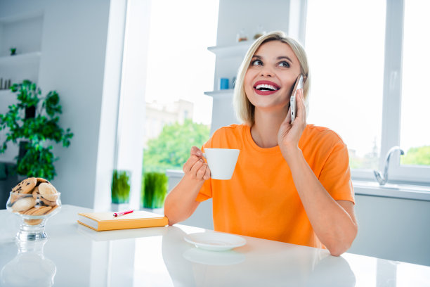 积极的女士坐在现代餐厅的照片，喝咖啡浓缩咖啡和朋友说小玩意图片下载