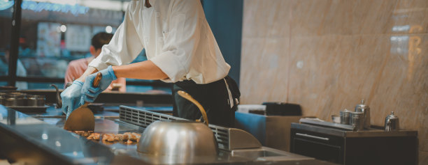 重点手日本料理厨师精心料理工作热桌，向顾客展示您的烹饪技巧，包括肉类和蔬菜烧烤，日本铁板烧餐厅，头部全景图片下载