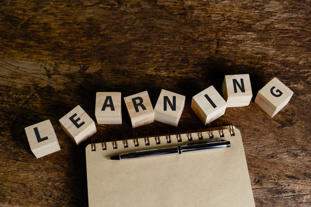 木块立方体与文本学习笔在木桌上的笔记本。经营理念以学习为目标。教育与知识观念。图片下载