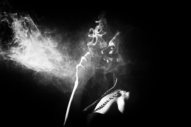一个黑发模特在工作室抽烟的黑白照片图片下载