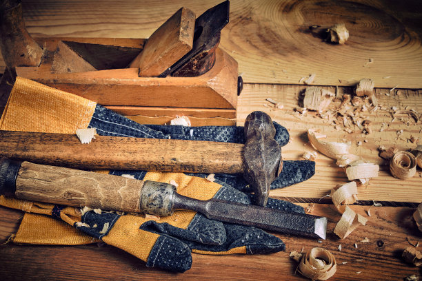 木匠工具包，锤子，凿子和飞机与手套木制背景。图片下载