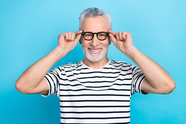 有趣的老男人的照片肖像触摸眼镜试检查视力穿时髦的条纹服装孤立的蓝色背景图片下载