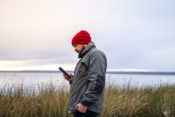 留胡子的男孩在阴天玩手机图片下载