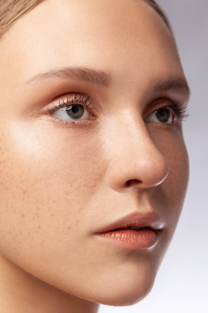 专注集中的美丽的女人与自然化妆模型看远，精心修饰的皮肤。图片下载