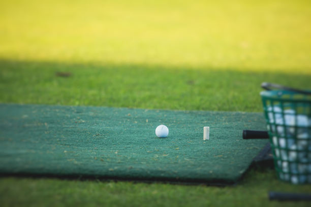 在练习场练习和训练挥杆的高尔夫球手群体，在高尔夫球场上打球的男子，在高尔夫综合俱乐部度假胜地的高尔夫球图片下载