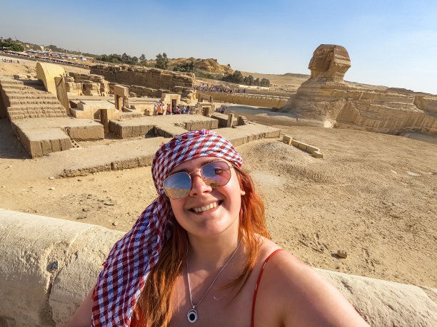 年轻女人在开罗吉萨大狮身人面像前自拍图片下载