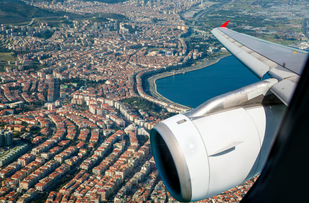 白色客机飞越现代伊兹密尔市图片下载