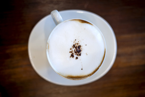 木桌上白色杯子里的咖啡俯视图。图片下载