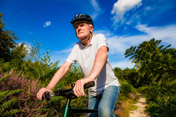 骑山地车的资深男子在森林小路上图片下载