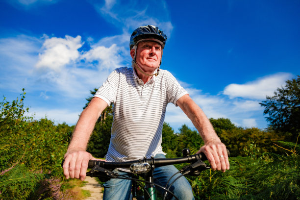 骑山地车的资深男子在森林小路上图片下载