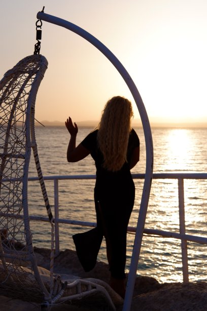 在日落海边跳舞的年轻女子图片下载