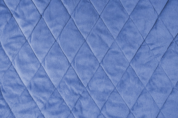 绗缝的蓝色丝绒织物背景，褶皱柔软的毯子表面图片下载