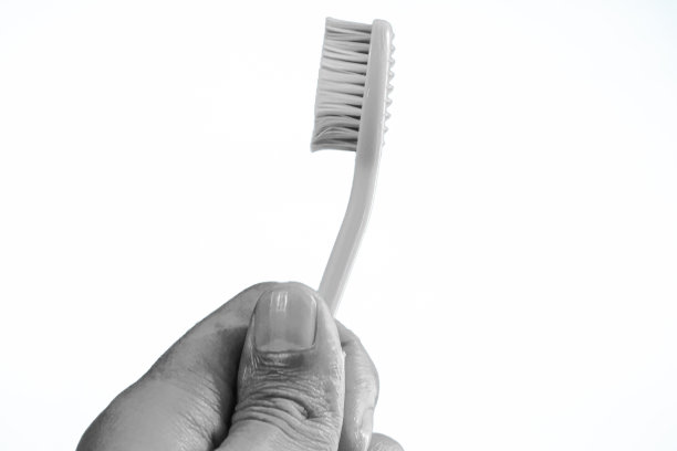 在白色背景上拿着牙刷。图片下载