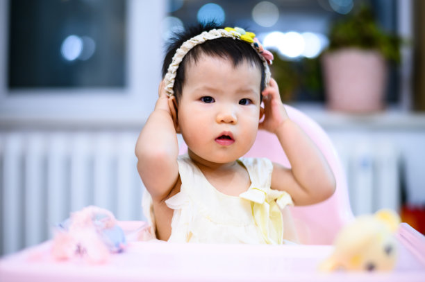 亚洲可爱的小婴儿坐在餐厅的婴儿餐椅上图片下载