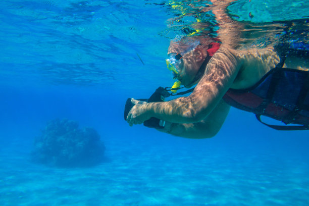 在埃及红海珊瑚礁水下浮潜拍照的男人图片下载