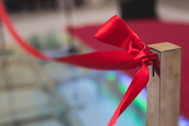 剪彩过程中，新购物中心商场大楼隆重开幕，展览开幕，近距离观看红丝带与周围的人图片下载