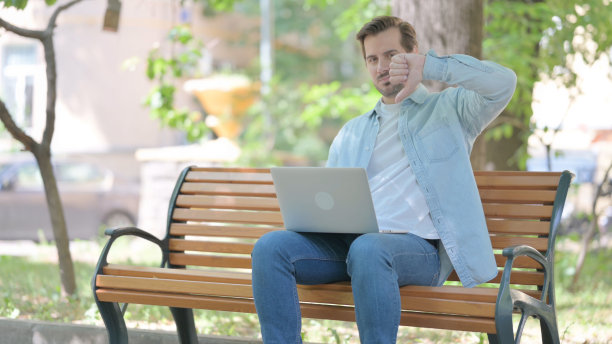 年轻人在户外用笔记本电脑工作图片下载