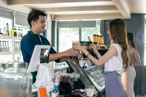 微笑的亚洲咖啡师自豪地在咖啡店提供咖啡图片下载