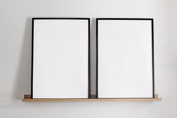 艺术模型模板。竹木架子上的两个黑色竖相框。白色的墙壁背景。家里的海报，简约的斯堪的纳维亚设计，没有人。优雅的公寓概念。图片下载