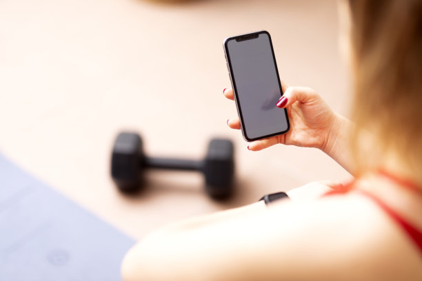 无法辨认的健身女性在手机上看空白屏幕图片下载